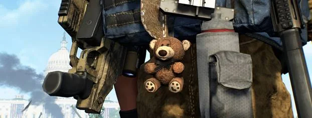 In-game still from Tom Clancy's The Division 2: a small brown teddy bear clipped to the back of an agent's tactical backpack