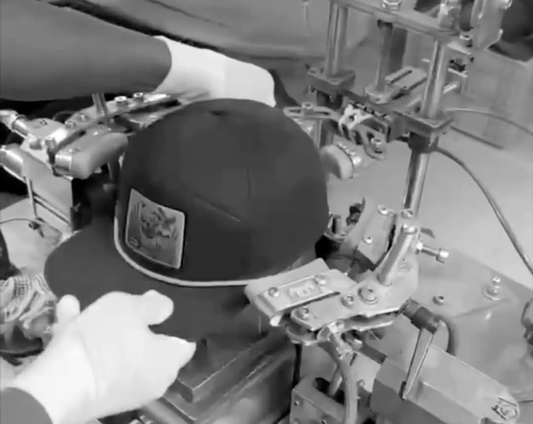 A cap crown being formed on a heated mould in our Bangladesh factory